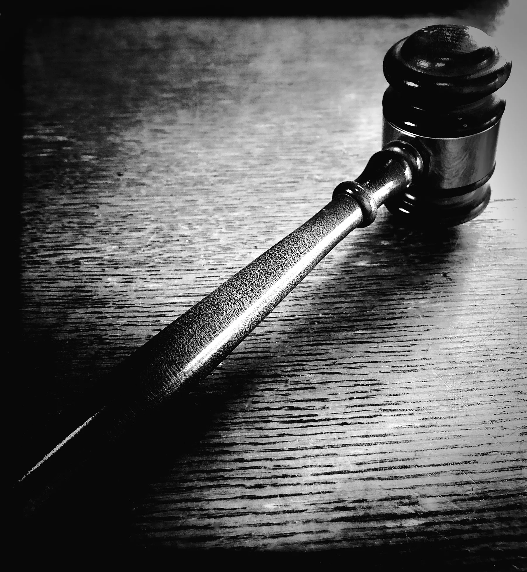 A judge’s gavel along a wooden surface