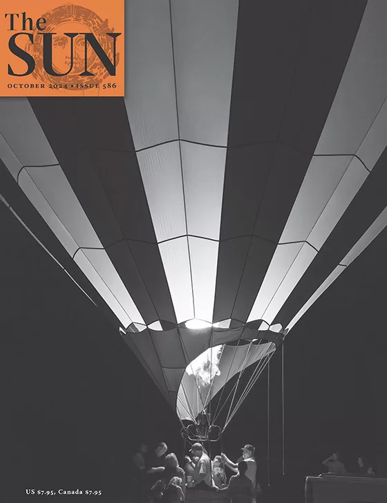 Issue 586 Cover October 2024 cover of The Sun. Crew preparing for a nighttime liftoff at the Alabama Jubilee Hot-Air Balloon Classic in Decatur, Alabama. The hot-air balloon and crew are lit by the balloon’s fire glow.