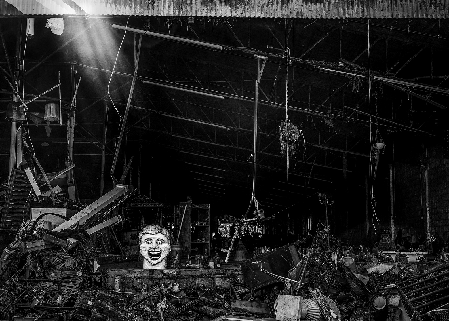 Debris and laughing head on stage in warehouse