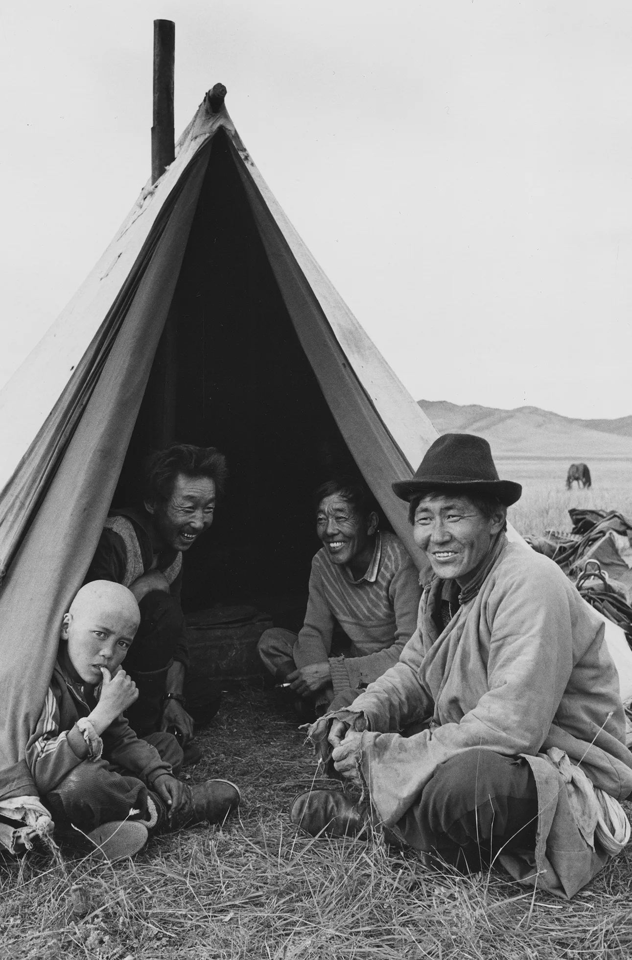 People sitting in and outside a tent in Mongolia