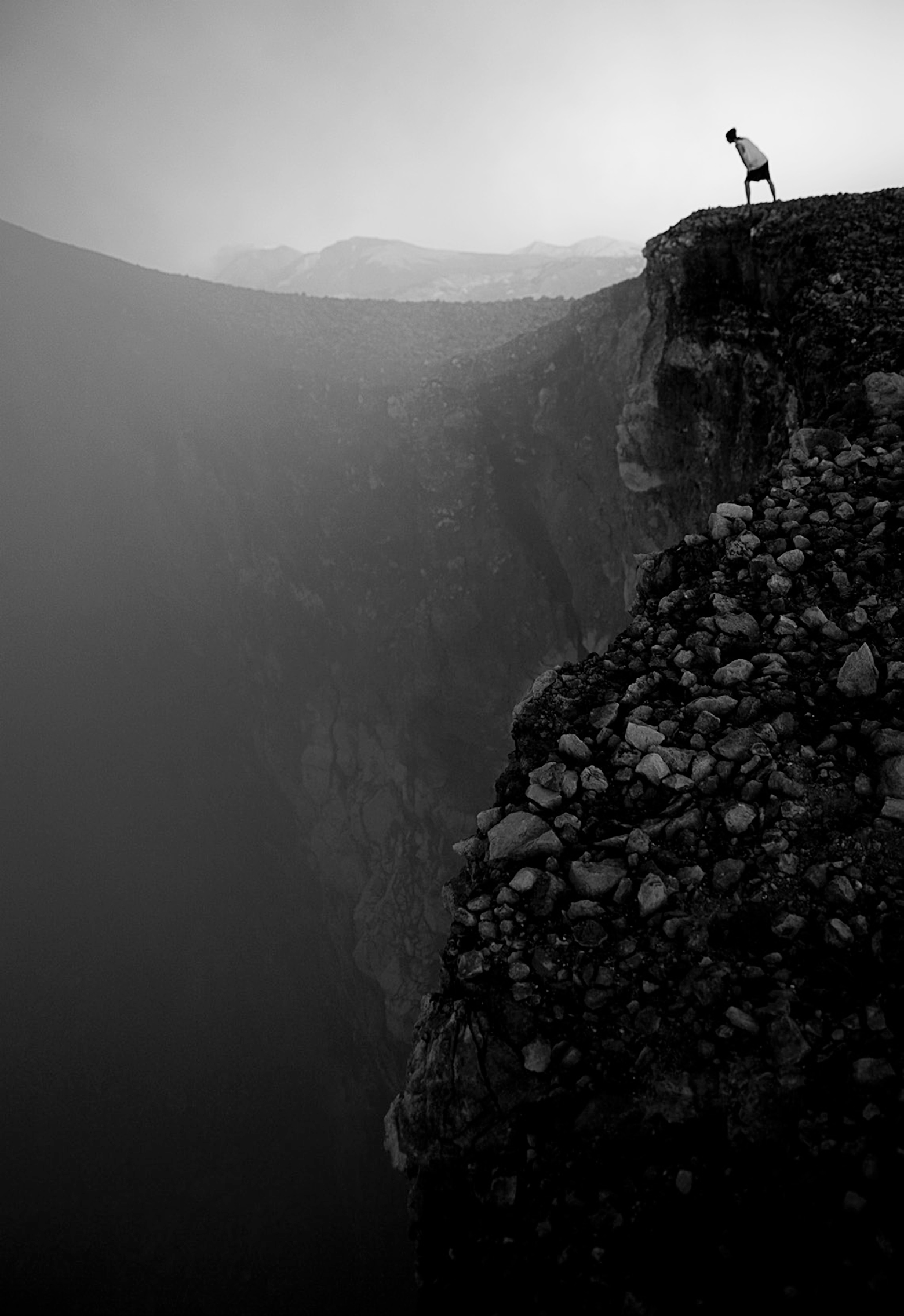 Person looking over a cliff down into a chasm