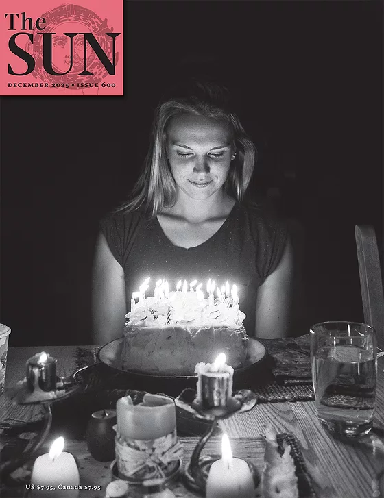 The Sun Magazine December 2025 Cover The photographer’s wife on her twenty-third birthday ready to blow out candles on her cake. Photo by Fernando Gomes.