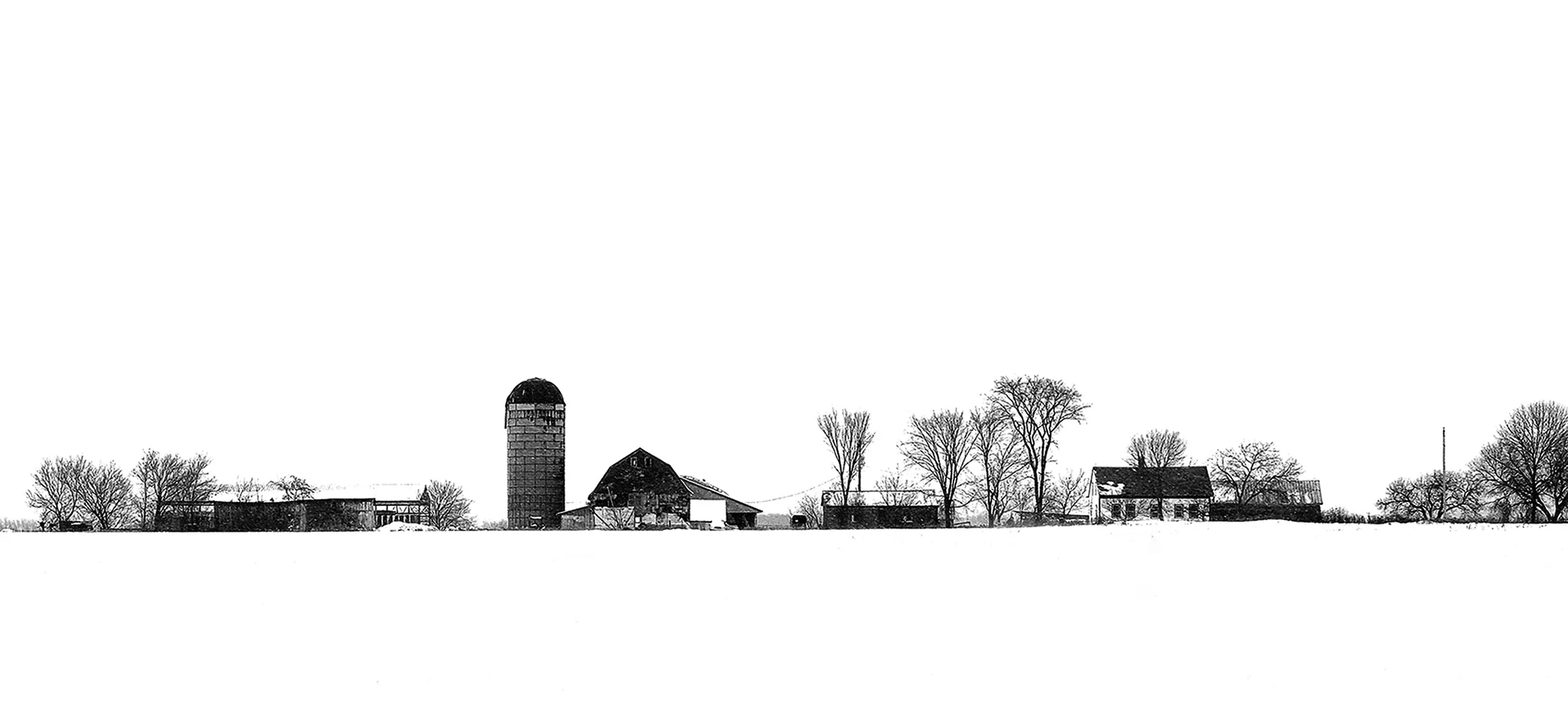 Roadside farm scene on a gray winter day near Whiting, Vermont. A silo, barn, house, and various buildings are on snow-covered ground with bare-branched trees interspersed throughout.